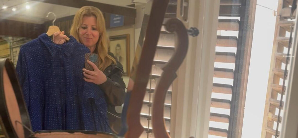 Private tour guide standing in a traditional Hungarian blue dyeing workshop in Pápa, surrounded by indigo fabrics and patterns